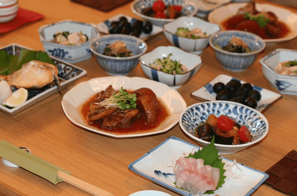 【屋久島住宿】「屋久之宿田口旅館（Yakunoyado Taguchi）提供的日式晚餐，多道家常料理與新鮮刺身，以精緻瓷盤呈現，展現旅館用心的手作餐點。」