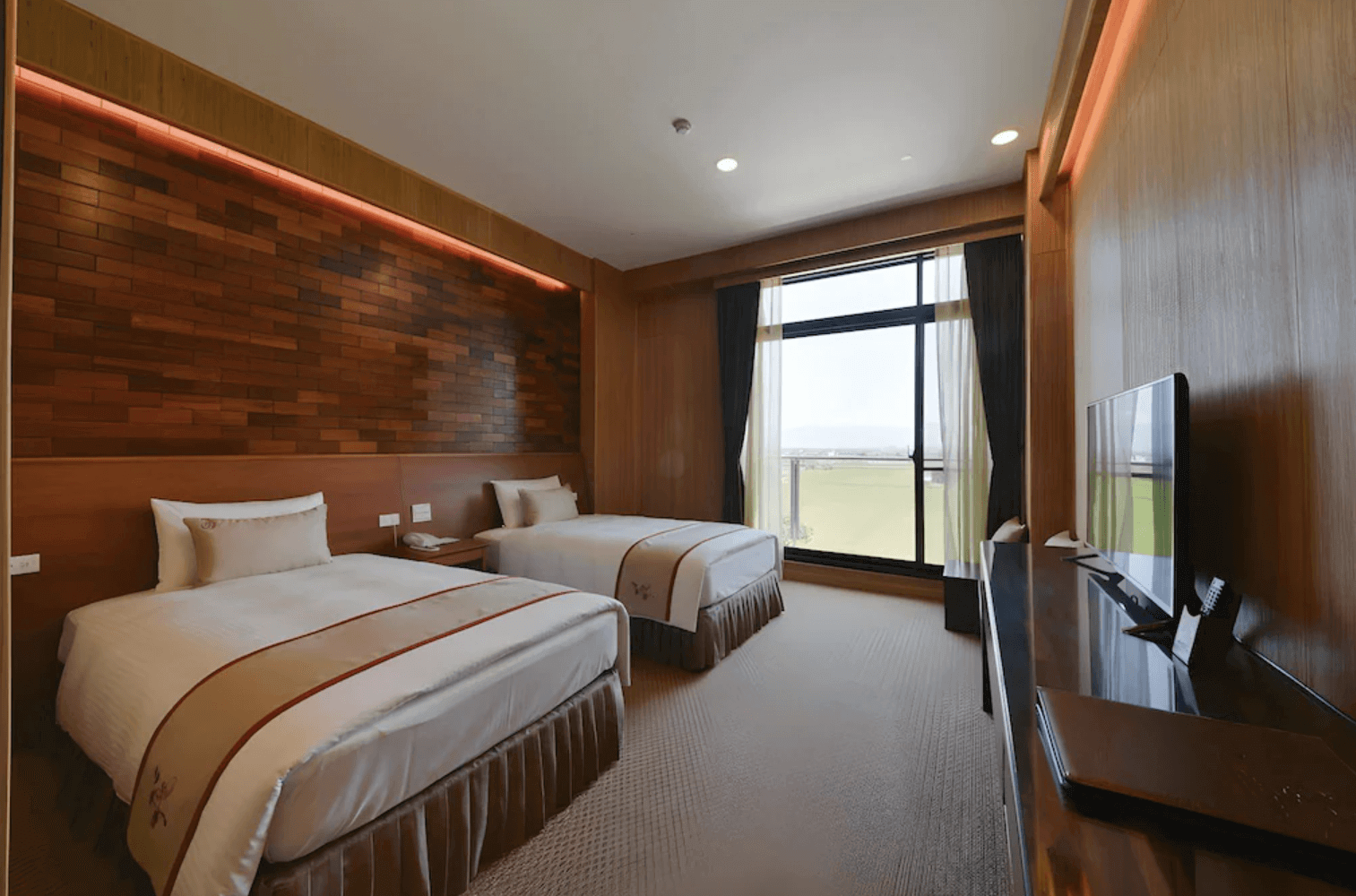 【宜蘭溫泉飯店】「山多利大飯店雙床房，採用木質調牆面與柔和燈帶照明，房內兩張獨立床鋪與大片落地窗採光良好，可眺望田野景觀，整體空間寬敞明亮。」