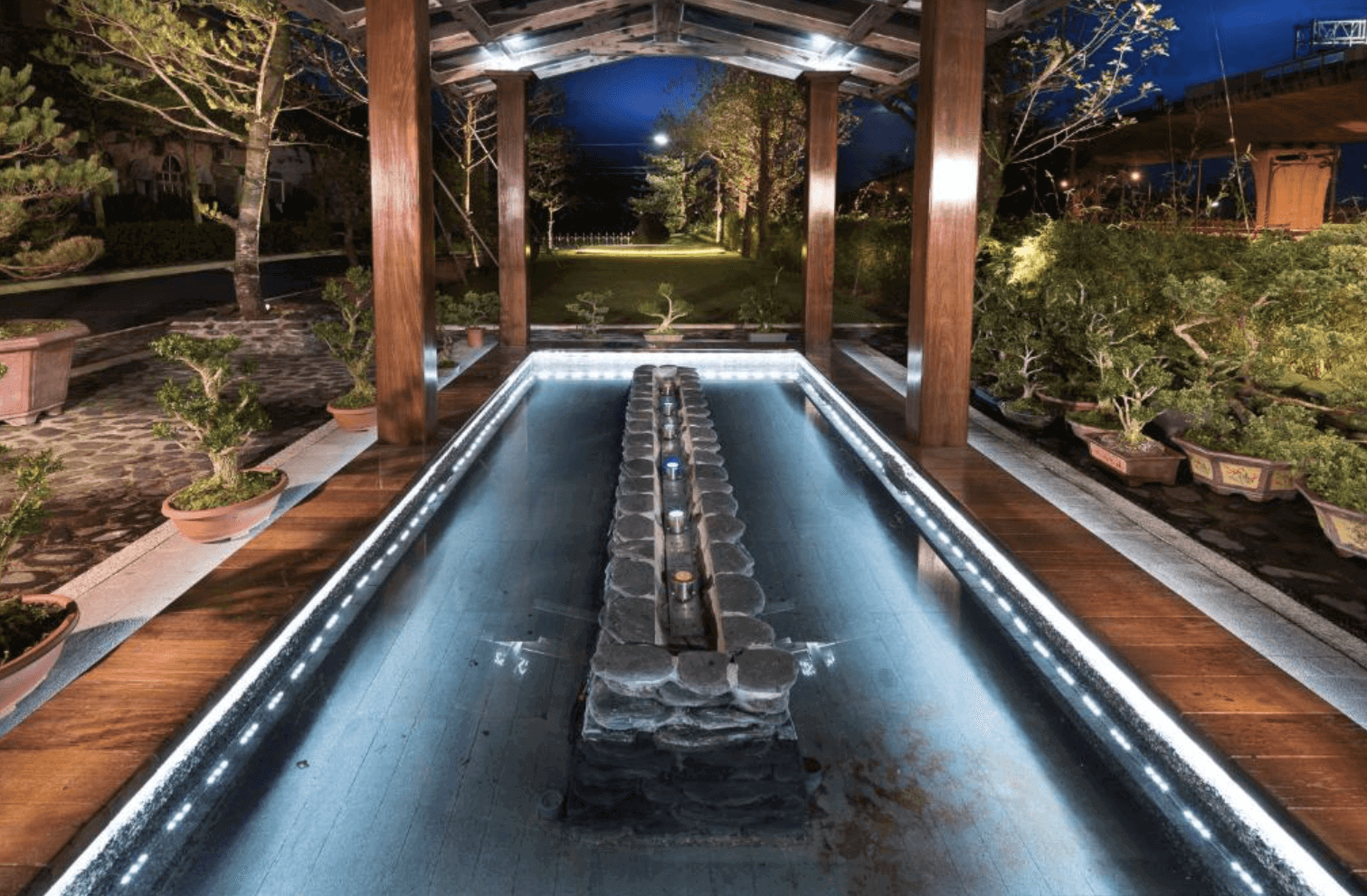 【宜蘭溫泉飯店】「山多利大飯店戶外溫泉泡腳池，設於亭式建築下，池中以石材環繞並配有夜間燈光，周邊綠意環繞，營造靜謐放鬆的溫泉氛圍。」