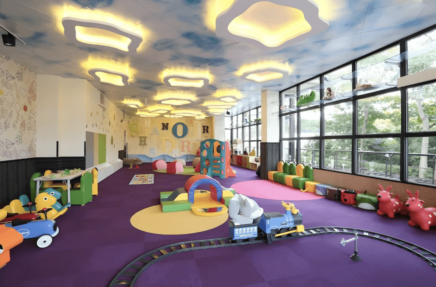 【宜蘭溫泉飯店】「山多利大飯店兒童遊戲室，空間以雲朵造型天花板與繽紛彩色地墊打造童趣風格，配置滑梯、積木、跳跳馬與迷你火車軌道，適合親子共玩。」
