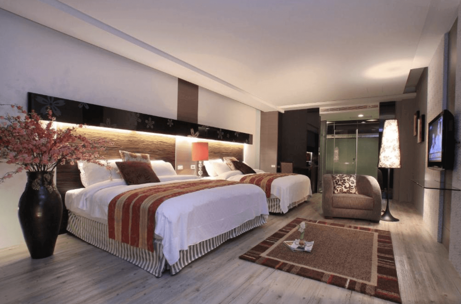 【宜蘭溫泉飯店】「春水笈溫泉渡假會館」— 溫馨四人房內部空間，兩張大床搭配暖色系燈光與花藝佈置，呈現舒適柔和的住宿氛圍。