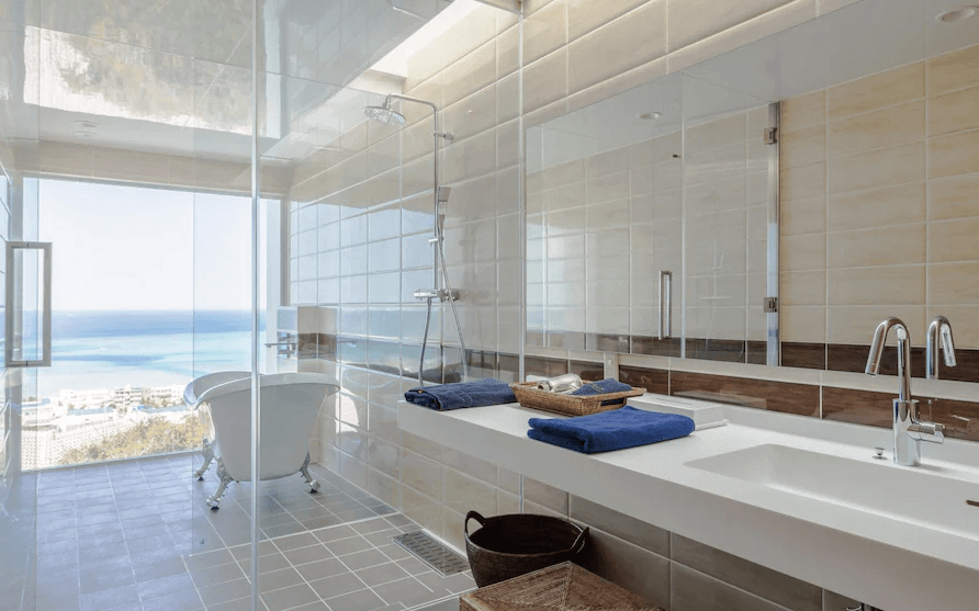 【讀谷村住宿】「沖繩本島T客房公寓的海景浴室，設有獨立浴缸、寬敞淋浴間與雙人洗手台，大面積透明窗戶可欣賞湛藍海景，呈現高質感的度假享受。」