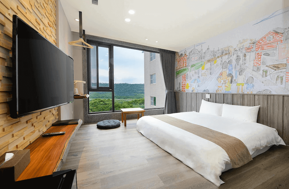 【大溪住宿】秘境41民宿 雙人房，大片落地窗可欣賞山林景色，牆面繪有大溪老街插畫風格壁畫，搭配木質地板與簡約家具，明亮舒適。