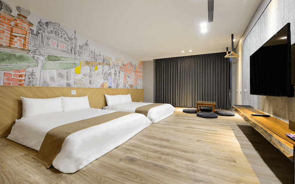 【大溪住宿】秘境41民宿 家庭房，兩張大床鋪設木質地板，牆面彩繪大溪老街圖案，空間寬敞明亮並設有小茶几與和風坐墊，適合親子入住。