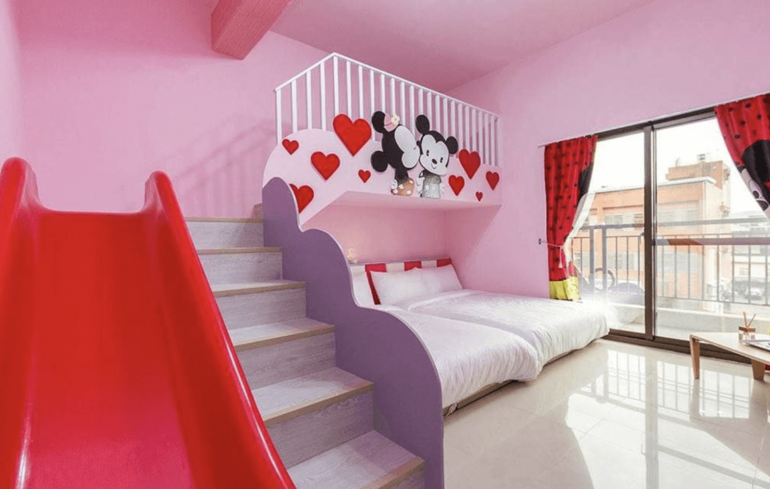 【東華大學民宿】「童樂會親子民宿」粉紅米奇主題親子房，設有可愛紅色溜滑梯與雙大床，牆面裝飾紅心與卡通圖案，空間明亮寬敞，非常適合親子入住。