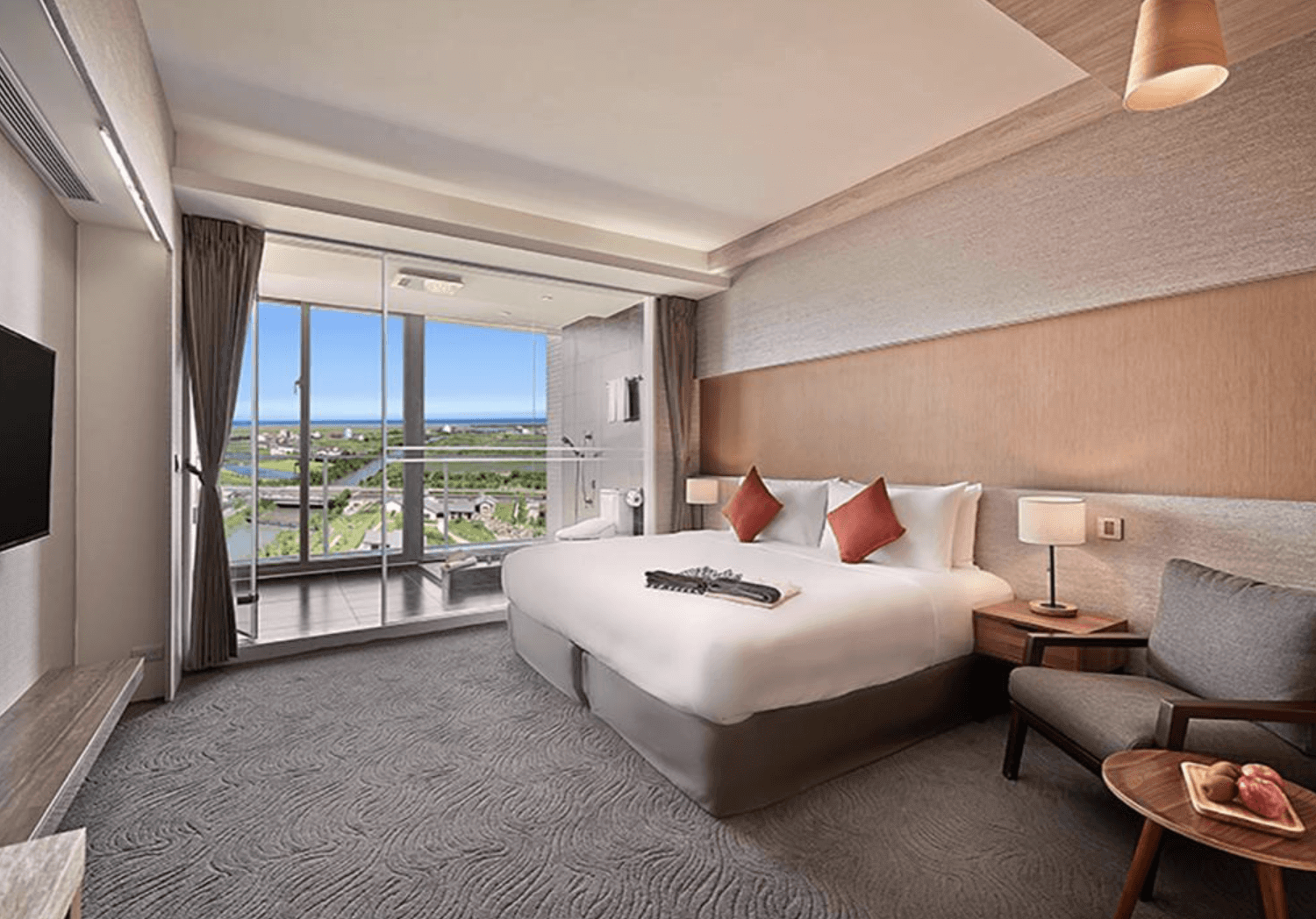 【宜蘭溫泉飯店】「綠舞國際觀光飯店客房景觀房，房內設有大床、落地窗與獨立陽台，窗外可欣賞蘭陽平原與遠方海景的開闊視野。」