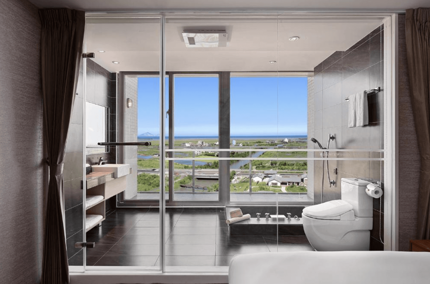 【宜蘭溫泉飯店】「綠舞國際觀光飯店浴室空間，採用落地玻璃設計可眺望蘭陽景色，內含浴缸、淋浴間與乾濕分離衛浴設備。」