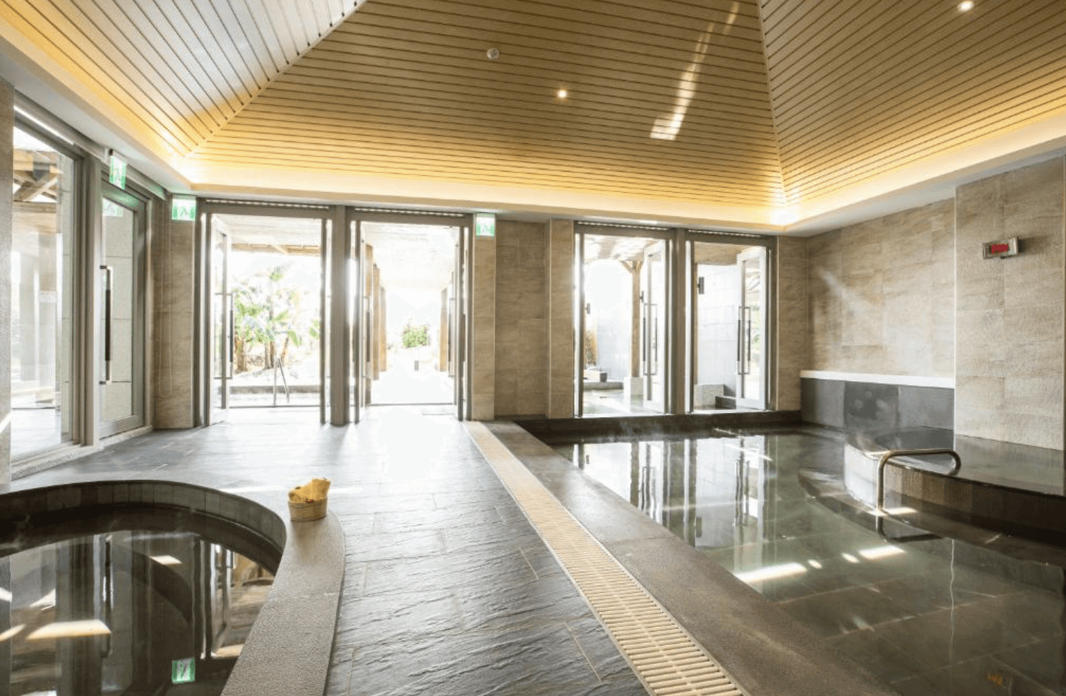 【宜蘭溫泉飯店】「綠舞國際觀光飯店大眾湯室內溫泉池，採木質天花與石材地面設計，設有多個溫泉池並享有自然光照入的舒適泡湯環境。」