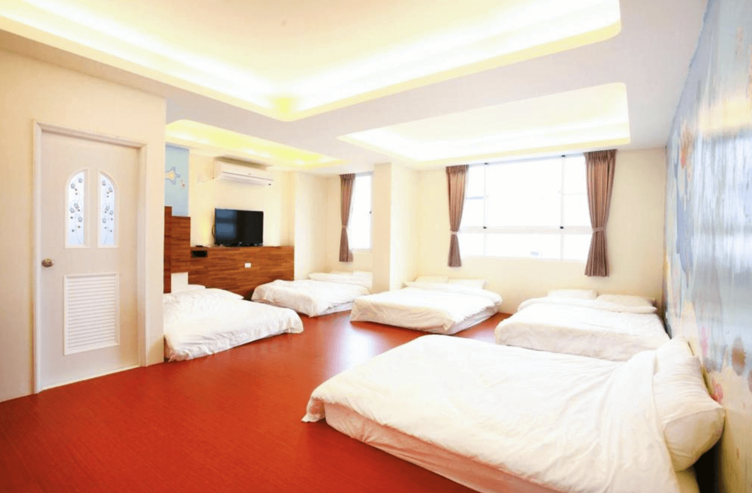 【綠島寵物友善住宿】「綠島美人魚民宿的多人家庭房，設有多張床舖與明亮窗戶，空間寬敞通風，適合家族或團體入住，牆面彩繪增添趣味感。」