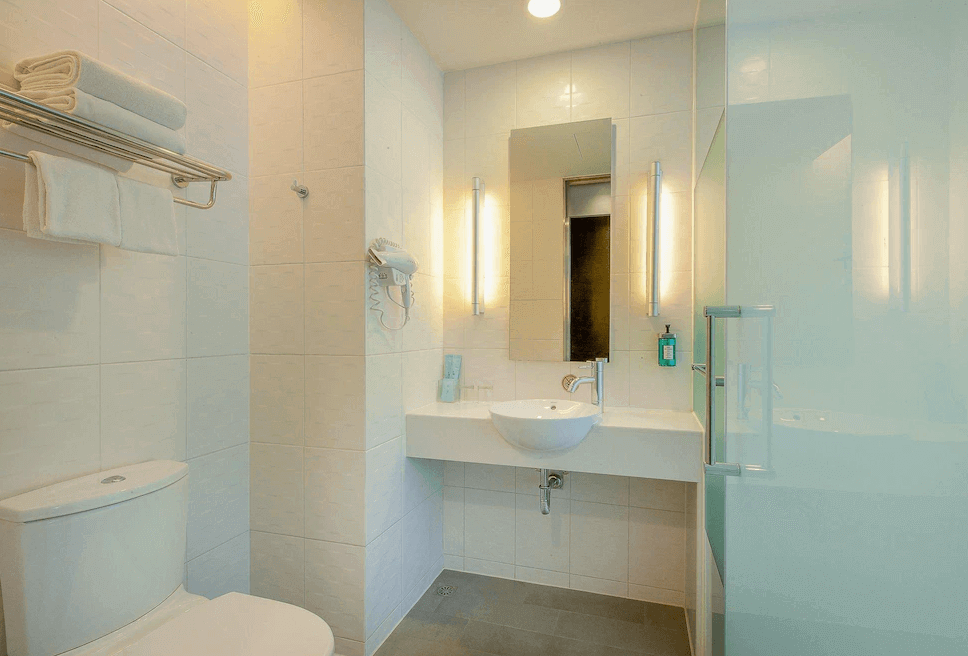 【台中火車站住宿】「臺中公園智選假日飯店浴室，採用白色明亮設計，配有洗手台、鏡面照明、淋浴間及毛巾置物架。」