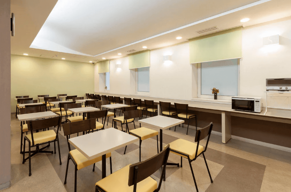 【北見住宿】舒適北見酒店的早餐用餐區，明亮整潔的環境搭配淺綠與米色設計，設有多張方桌與椅子，提供自助式早餐及輕食空間。