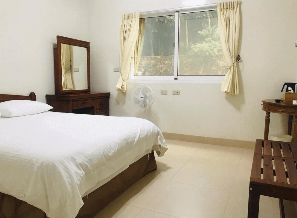 【瑞里住宿】「茗軒竹民宿單人房｜明亮乾淨的白色寢具與木質梳妝台設計，窗外可見山林景色，空間整潔舒適。」