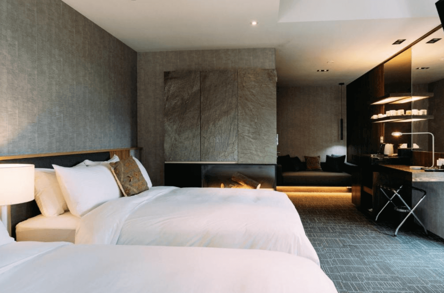 【宜蘭溫泉飯店】「藏闊渡假會館」— 現代風格的雙床房，沉穩灰調搭配大地色裝飾，房內設有舒適沙發區與間接照明，整體空間質感高雅、溫馨舒適。