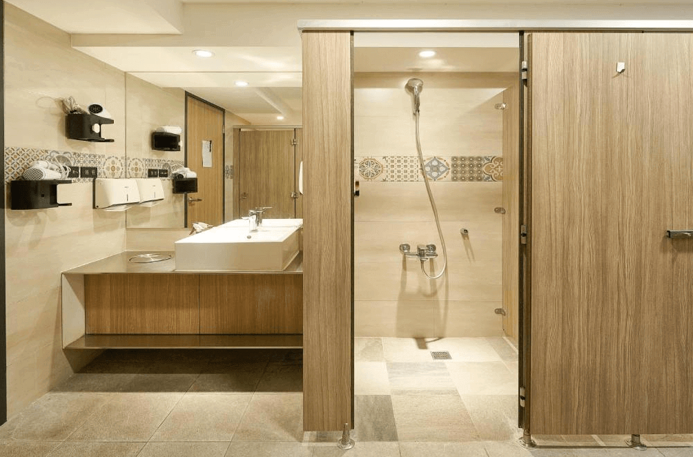 【台中火車站住宿】「逗點 inn Hotel 的衛浴空間採用木質與米色系設計，設有乾濕分離淋浴間、寬敞洗手台與整齊收納架，環境明亮乾淨。」