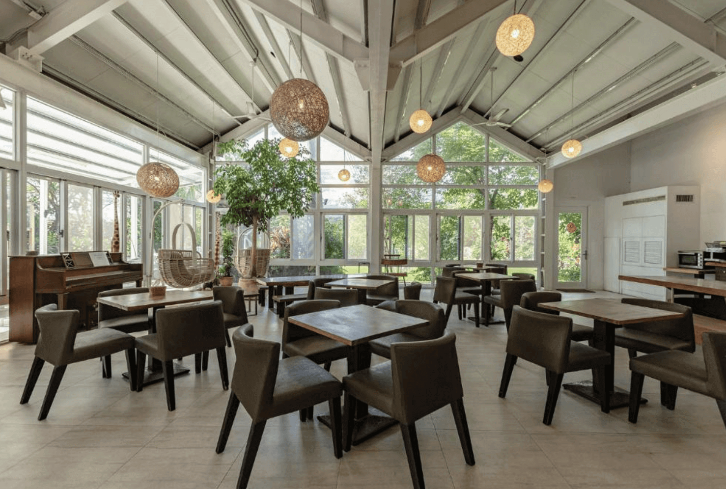 【東華大學民宿】「雲上太陽民宿」餐廳空間，挑高設計搭配大片落地窗引入自然光線，木質桌椅與球型吊燈營造舒適明亮氛圍，適合享用早餐與下午茶。