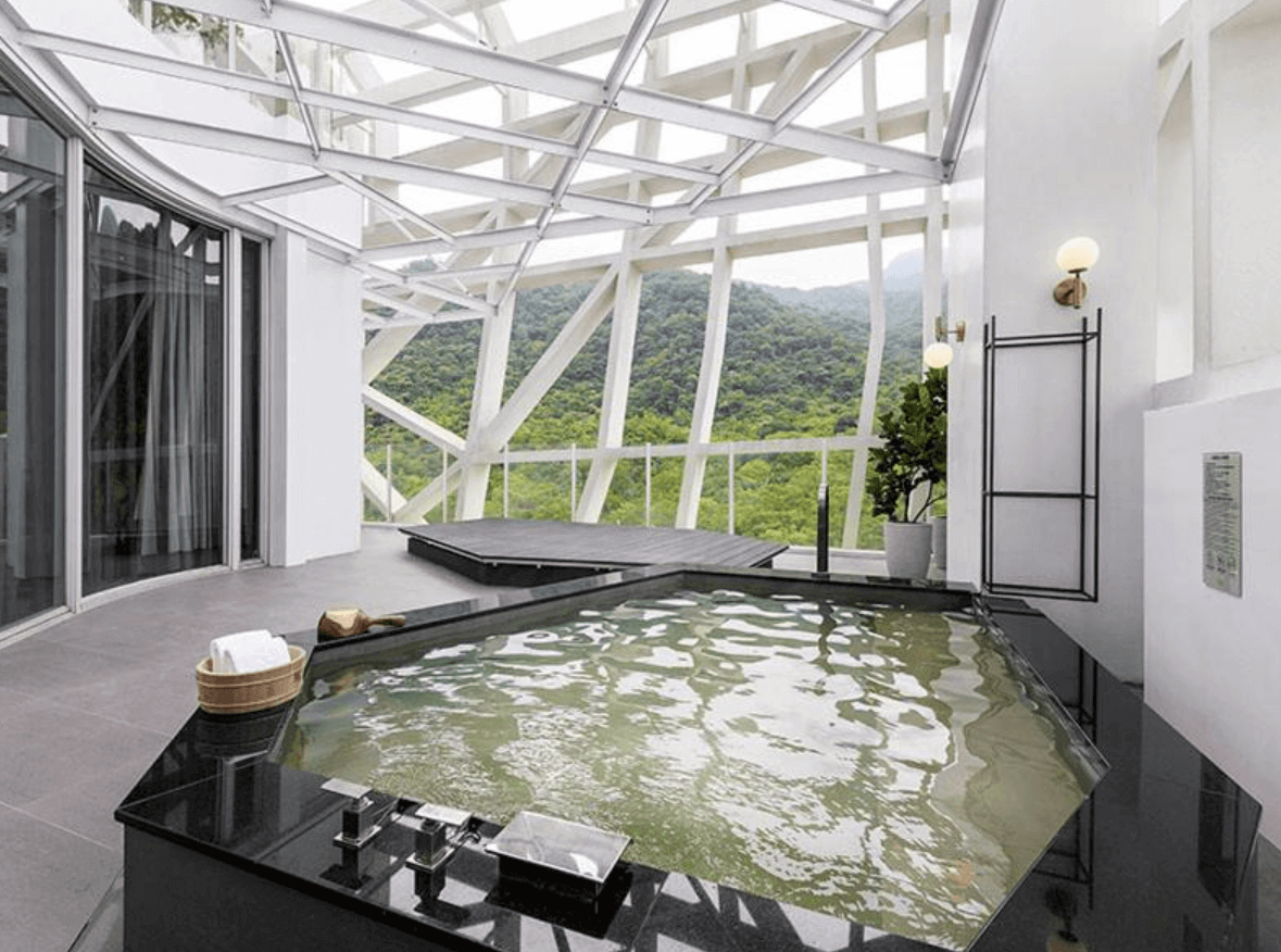 【宜蘭溫泉飯店】「風華渡假酒店・礁溪館私人半露天溫泉池，黑色石材打造的泡湯池搭配山景視野，周圍以白色結構框景設計，呈現開闊又時尚的度假氛圍。」