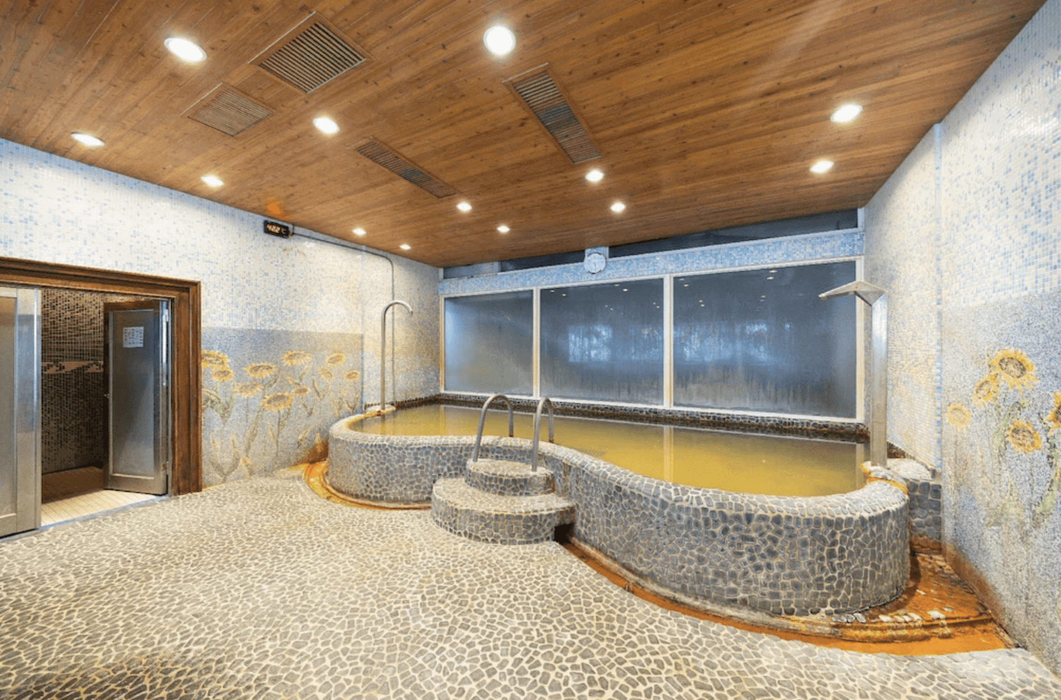 【宜蘭溫泉飯店】「香格里拉渡假飯店」— 室內溫泉大眾池，採用石材池壁與自然風格馬賽克磁磚，溫泉水呈現金黃色調，搭配木質天花板營造原始放鬆感。