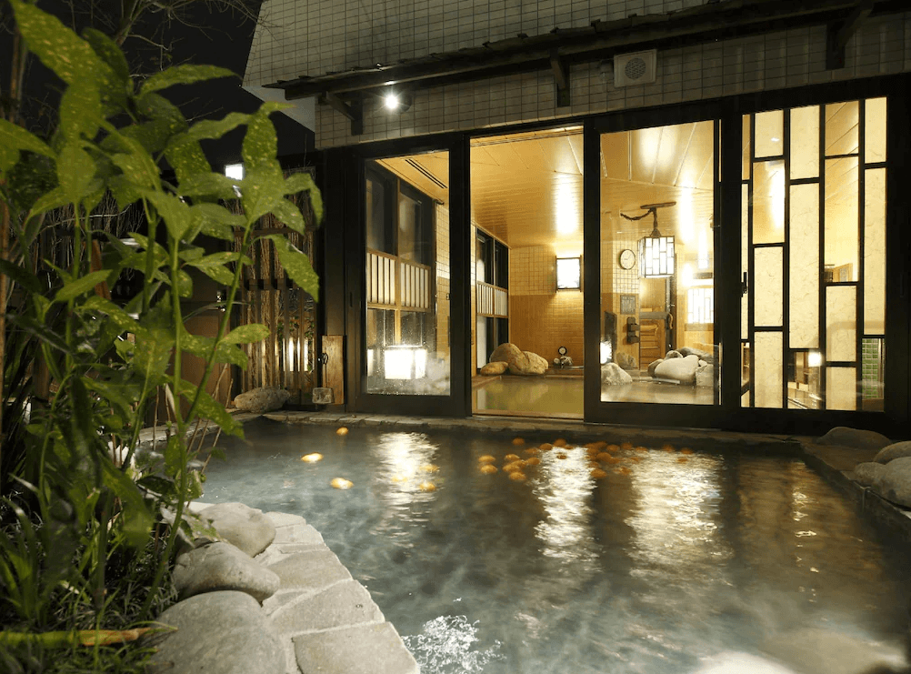 【鹿兒島住宿】Dormy Inn飯店-鹿兒島天然溫泉 的特色露天風呂，石造浴池中漂浮著鮮黃的柚子（或柑橘），讓旅客在享受天然溫泉的同時，體驗獨特的香氛與風雅氛圍。