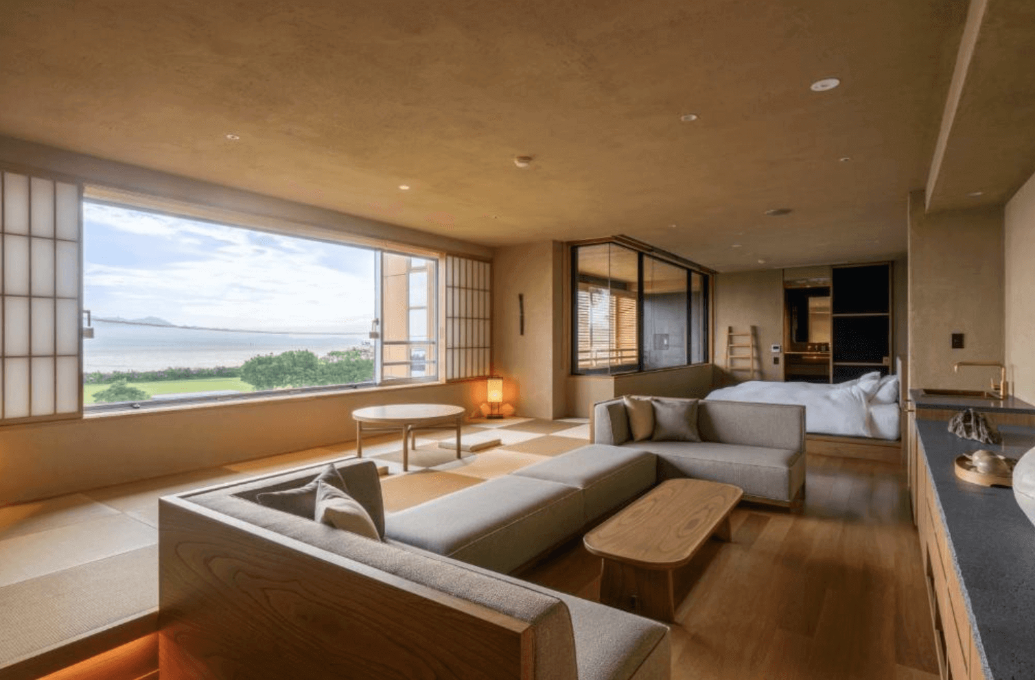 【指宿住宿】Koran之湯錦江樓 (Ryokan Koran no Yu Kinkouroh) 的頂級奢華套房，採用現代日式設計，擁有下沉式沙發客廳與寬敞榻榻米區，透過全景落地窗將戶外海天一色的美景引入室內。