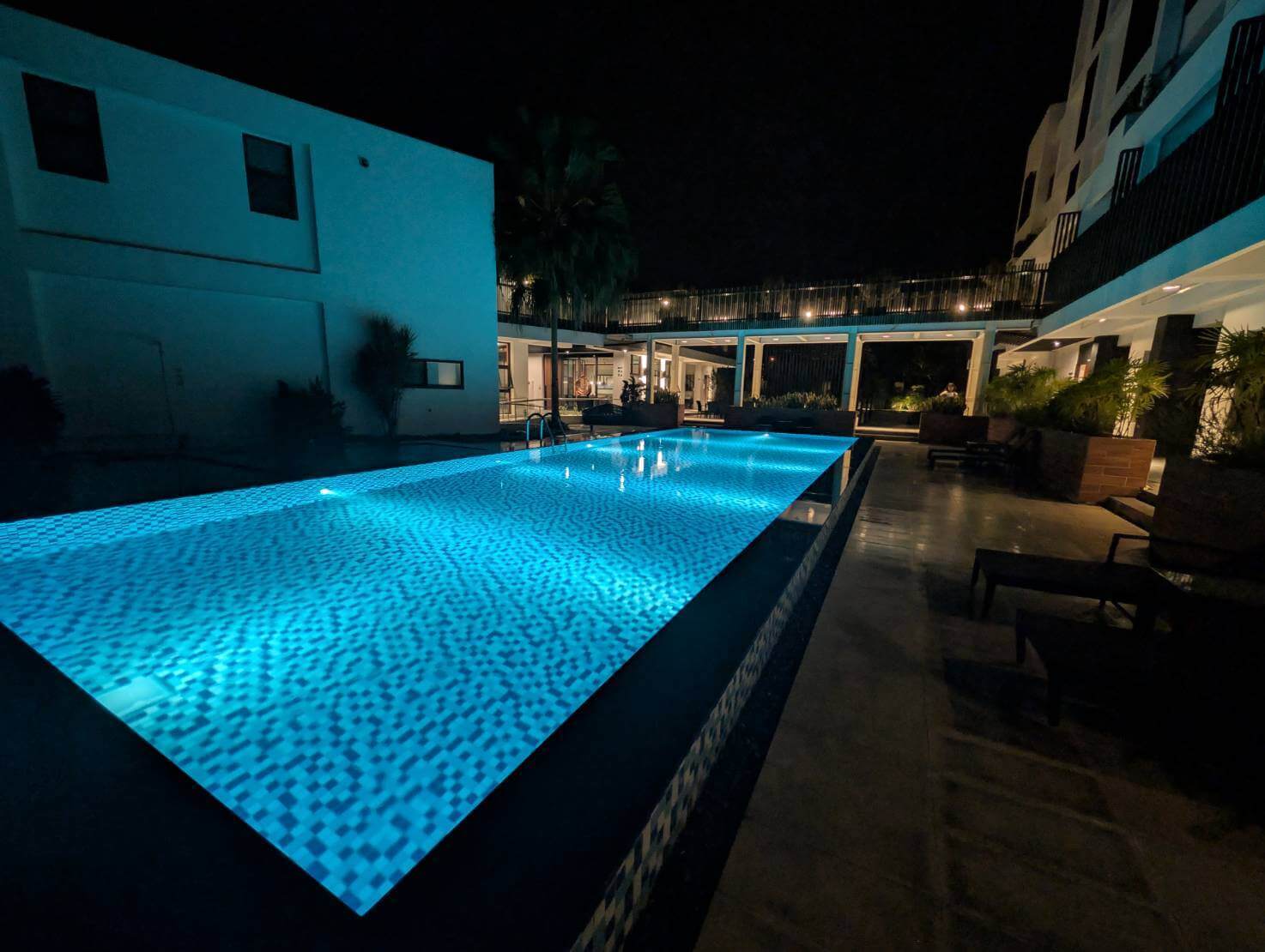 「元湯溫泉居夜間泳池景色，泳池燈光透出夢幻藍色光影，周圍建築與植栽在夜色中呈現靜謐氛圍。」