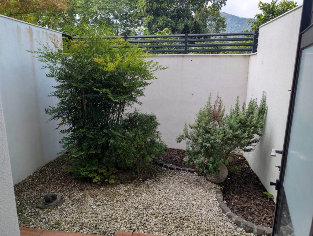 〈元湯溫泉居〉房型附設的小庭院，內有綠植、白石與自然造景，營造靜謐放鬆氛圍。