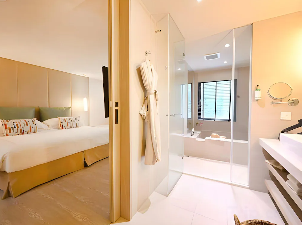 北投大地酒店 (The Gaia Hotel) 的客房衛浴視角，採用透明玻璃隔間增加空間通透感，配備寬敞的浴缸與現代化設施，讓旅客能一邊泡澡一邊享受寬敞的視野。