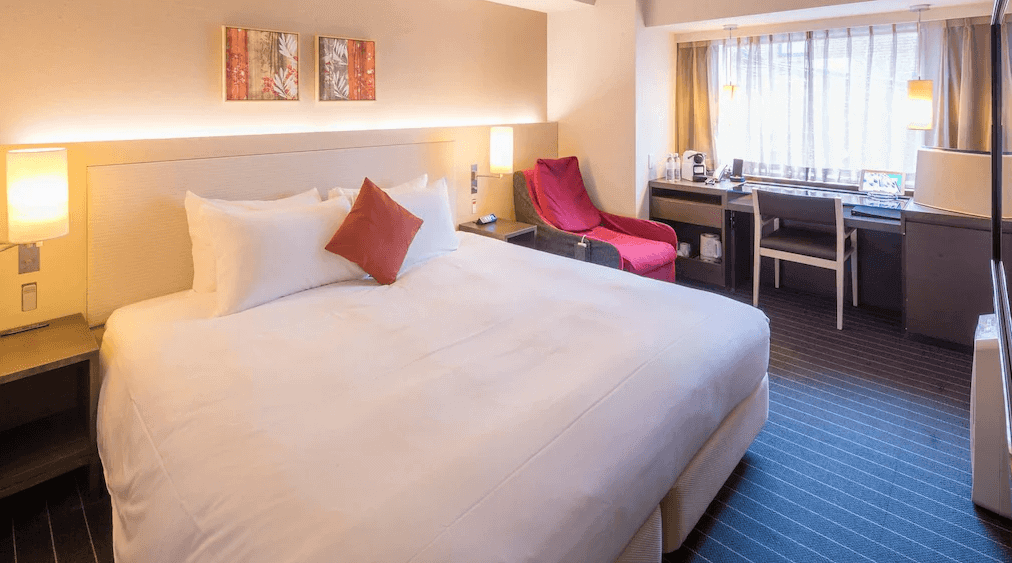 【大分住宿】大分Forza飯店 (Hotel Forza Oita) 的客房衛浴設施,採用黑地磚搭配白牆的對比設計,配備寬敞的浴缸、免治馬桶與貼心的安全扶手,空間整潔且機能完善。