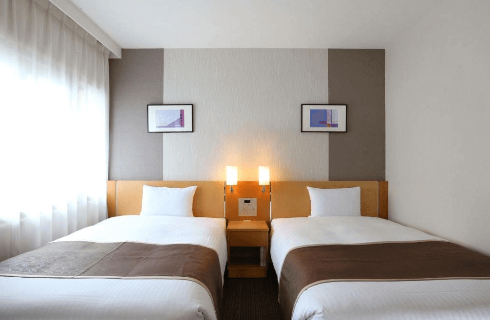 【大分住宿】大分JR九州布魯斯姆酒店 (JR Kyushu Hotel Blossom Oita) 的大廳休息區(或專屬酒廊),延續了標誌性的木質格柵屏風設計,配有舒適沉穩的沙發座椅與書架牆,為旅客提供一處安靜愜意的休憩空間。