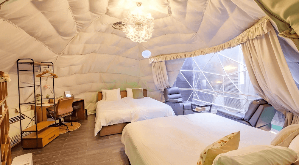 【霧島住宿】小鹿野溫泉美肌之湯飯店的豪華露營圓頂帳篷，內部懸掛水晶吊燈並設有舒適床鋪，透過透明帳幕可直接欣賞戶外自然景色。