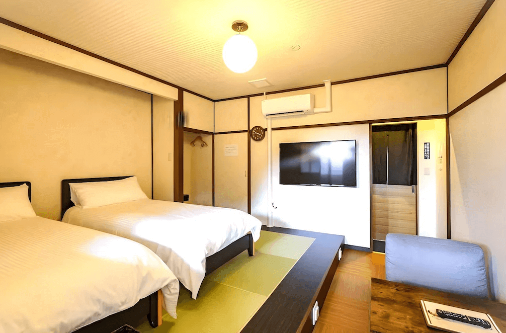 【霧島住宿】小鹿野溫泉美肌之湯飯店的客房，設計結合了現代簡約風格與日式元素，將西式床鋪設置於架高的榻榻米平台上。