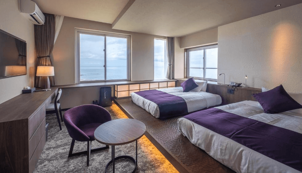 【屋久島住宿】「屋久島海洋與森林飯店（THE HOTEL YAKUSHIMA ocean & forest）海景雙床房，房內以紫色系寢具點綴，大片窗景可欣賞無邊海景，空間溫馨舒適。」