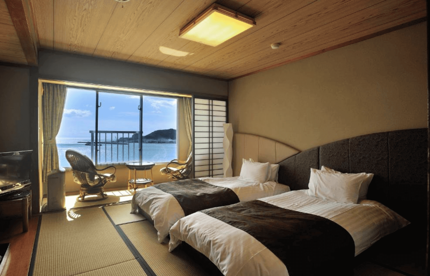 【指宿住宿】指宿皇家飯店 (Ibusuki Royal Hotel) 的海景和洋室，在舒適的榻榻米空間上配置了西式床鋪，落地窗旁特別擺設了休閒藤椅，讓旅客能愜意地欣賞錦江灣的海濱風光。