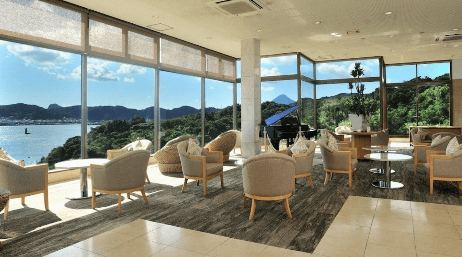 【指宿住宿】指宿皇家飯店 (Ibusuki Royal Hotel) 的景觀大廳，設有整面落地窗與優雅的三角鋼琴，視野極佳，可同時眺望蔚藍海景與遠方著名的「薩摩富士」開聞岳。