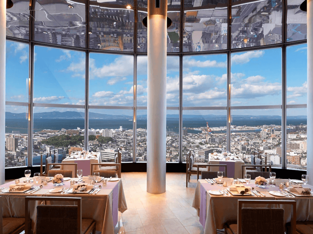 【大分住宿】日航大分綠洲塔酒店 (Hotel Nikko Oita Oasis Tower) 頂樓著名的法式景觀餐廳,擁有挑高空間與圓弧形的環景落地窗,旅客能在此一邊品嚐精緻料理,一邊飽覽別府灣與大分市區壯闊的海天一色。