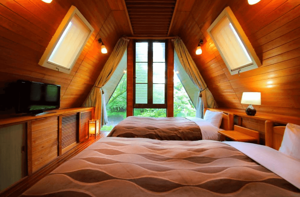 【霧島住宿】櫻櫻溫泉旅館的小木屋風格客房，採用全木質裝潢與獨特的三角形挑高屋頂設計，設有天窗與觀景窗，讓旅客宛如住在森林小屋中。