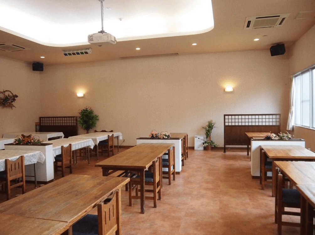 【屋久島住宿】「田代旅館分館」的餐廳空間，以木質桌椅與溫暖燈光呈現簡潔舒適的用餐環境，空間寬敞明亮、佈置雅緻。