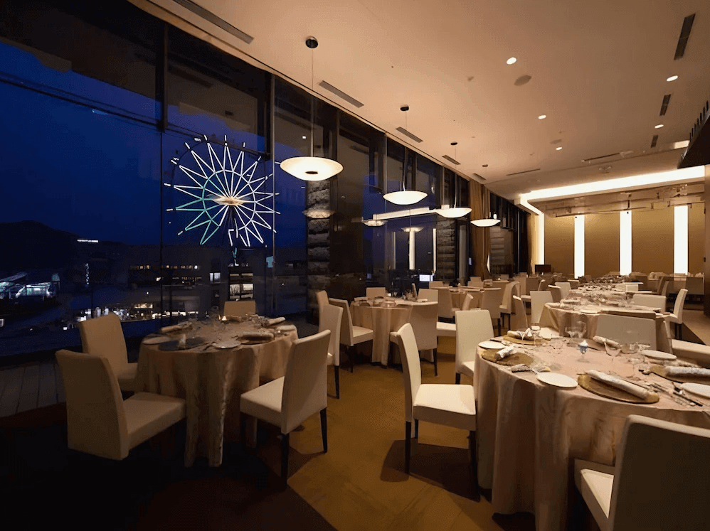 【鹿兒島住宿】索拉利亞西鐵飯店鹿兒島 (Solaria Nishitetsu Hotel Kagoshima) 的景觀餐廳，空間設計典雅高貴，透過整面落地玻璃窗，賓客可邊用餐邊欣賞著名的「阿姆蘭」摩天輪與璀璨的鹿兒島夜景。