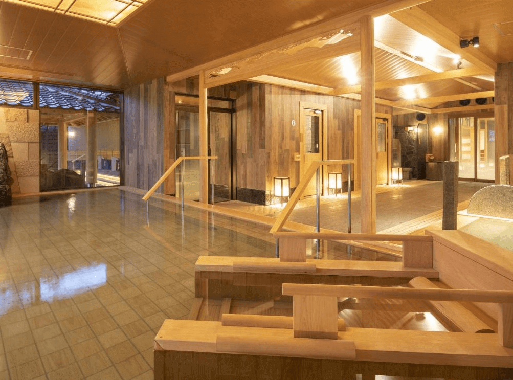 霧島山拉維斯塔飯店的大浴場，採用溫潤的木質樑柱與石材地板設計，營造出寬敞且充滿濃厚日式風情的溫泉泡湯空間。