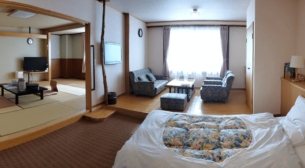 【霧島住宿】霧島溫泉旅人山莊飯店，寬敞舒適的和洋式客房，空間配置包含西式床鋪、沙發休息區以及傳統日式榻榻米起居空間。