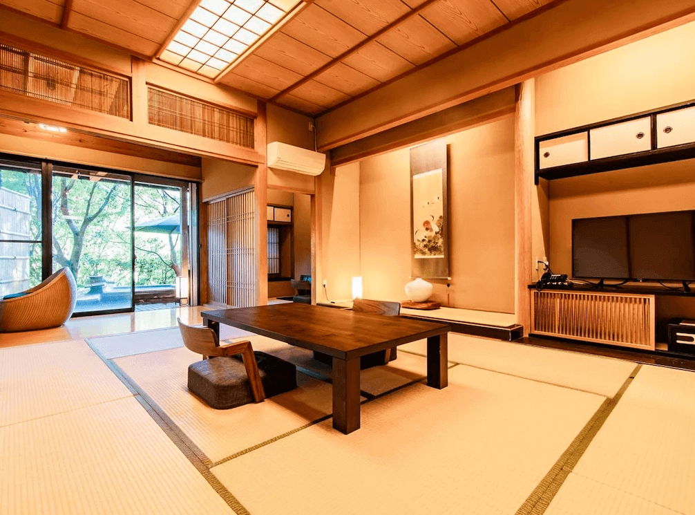 【霧島住宿】霧島紅葉谷清流莊的傳統日式和室，鋪設榻榻米並擺設原木矮桌與掛軸，空間寬敞靜謐，展現經典的日式居住美學。