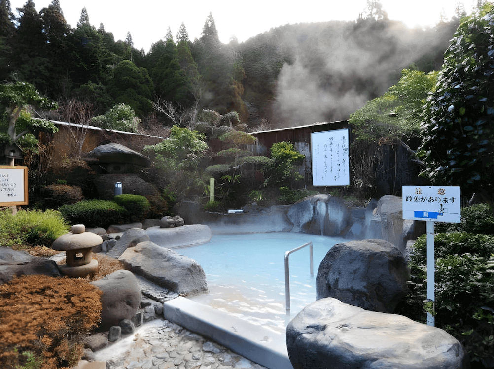 【霧島住宿】霧島酒店的戶外露天溫泉，泉水呈現獨特的乳白色，浴池以天然岩石砌成並被庭園綠意環繞，蒸氣氤氳中盡顯秘湯風情。