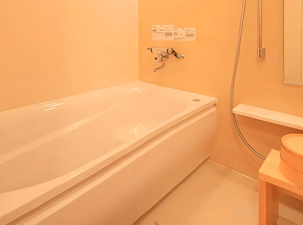 【鹿兒島住宿】鹿兒島華盛頓廣場飯店 (Kagoshima Washington Hotel Plaza) 的標準雙床客房視角，兩張單人床鋪設潔白寢具，中間設有床頭控制面板，房間底部為搭配米色窗簾的對外窗。