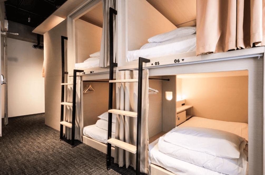 UNPLAN Shinjuku 的混合宿舍房,採用木質箱型上下舖設計,結構穩固,每床皆配有遮光拉簾與專屬閱讀燈,提供背包客既保有隱私又舒適的睡眠空間。