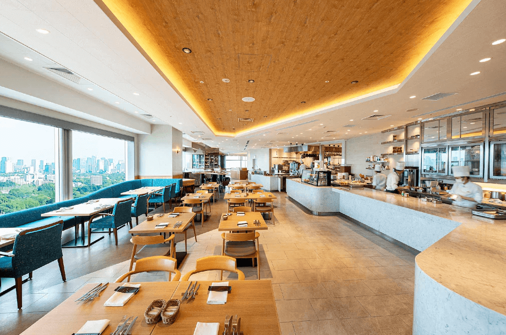 世紀南悅酒店的景觀自助餐廳,採光充足明亮,木質調裝潢搭配開放式廚房,窗外可俯瞰開闊的日間市景。