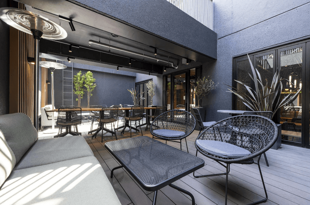 新宿歌舞伎町阿曼內克飯店的B1下沉式戶外露台,在這個半開放的庭院空間中,設有舒適的編織沙發與暖爐設備,是在喧鬧的歌舞伎町中難得一見的靜謐休憩角落。