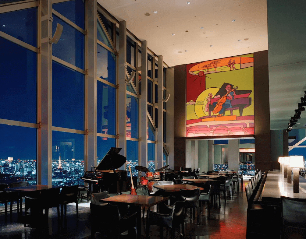 東京柏悅飯店的頂樓景觀酒吧(New York Bar),擁有挑高落地窗與巨幅爵士主題壁畫,可一邊俯瞰包含東京鐵塔在內的絕美夜色,一邊享受現場演奏的爵士樂。
