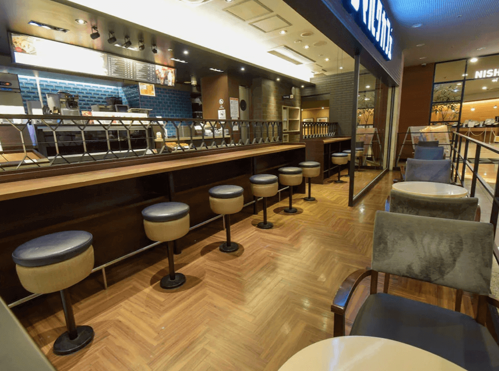 西鐵INN新宿附設的咖啡廳用餐區(Saint Marc Cafe),鋪設溫潤的人字拼木地板,設有靠窗的吧台高腳椅座位,提供旅客愜意的早餐或休憩環境。