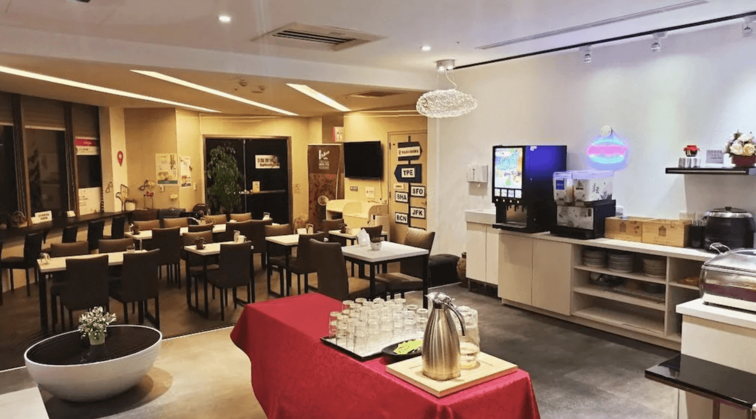 雀客快捷-新北淡水公共休憩用餐區，提供寬敞的座位與自助飲料吧，包含咖啡機與冷飲設施，環境整潔明亮，是旅客享用簡易餐點或休憩的好去處。