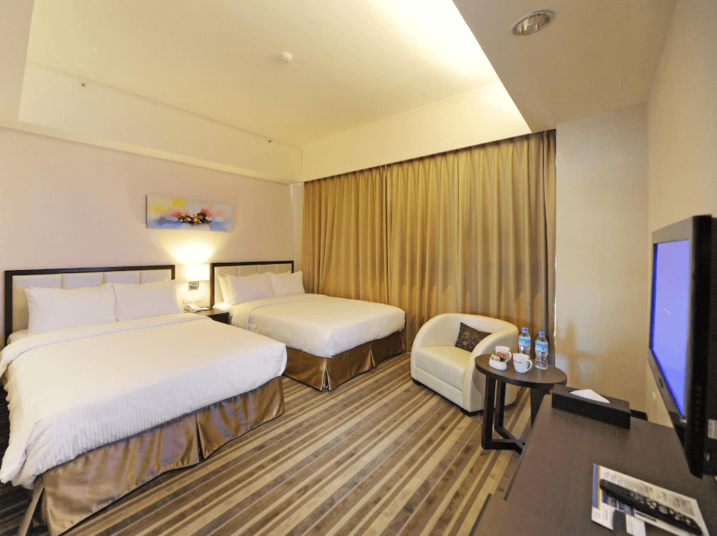 F Hotel 花蓮站前館的家庭四人房,房內配置兩張雙人床與舒適的小沙發座椅,並提供完整的備品與迎賓礦泉水,空間明亮且視野通透。