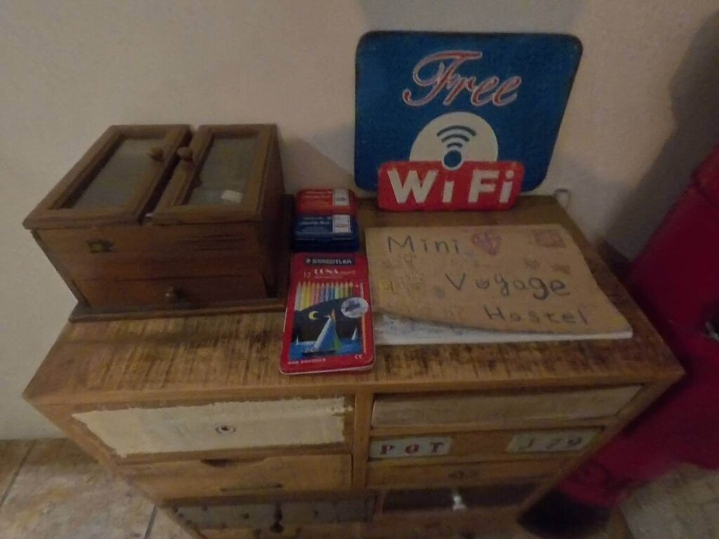 小旅行迷你公寓的復古木櫃上擺放著「Free WiFi」提示牌，旁邊附有色鉛筆與留言板，展現溫馨且貼心的住宿服務細節。